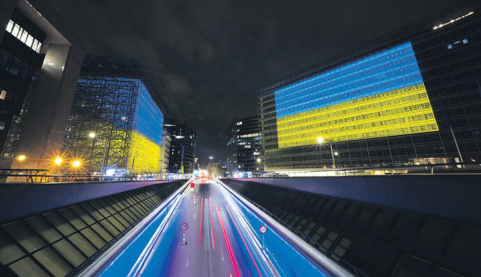 2月23日晚,布鲁塞尔欧盟理事会大楼(左)和欧盟委员会大楼亮起灯光,打上乌克兰国旗的颜色,纪念乌克兰战争届满4周年。法新社图