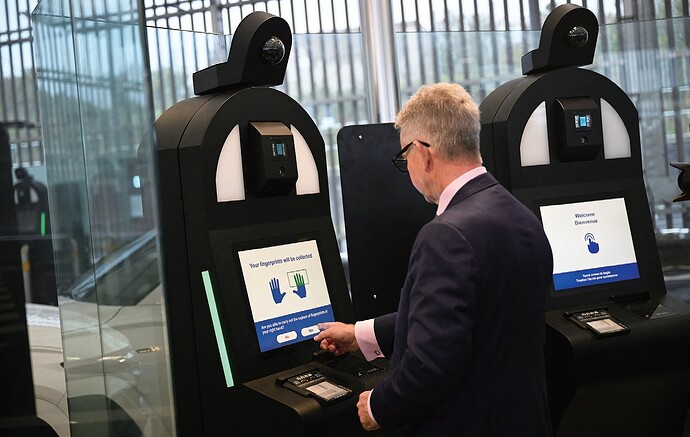图为9月23日英国东南部的英吉利海峡隧道举行的媒体展示活动中，一名工作人员演示欧盟电子出入境系统自助终端使用方式。法新社图